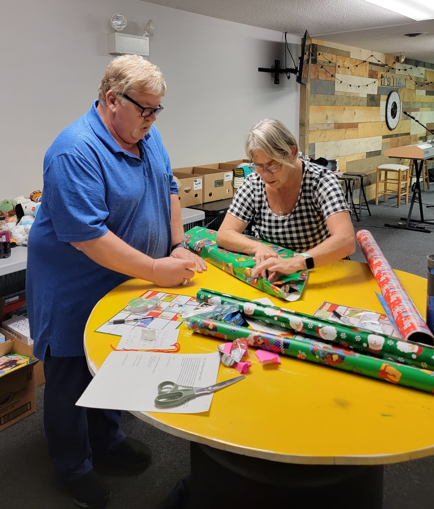 Volunteers wrapping donated gifts on a table