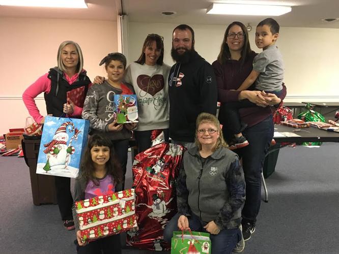 Family group posing together with wrapped Christmas gifts