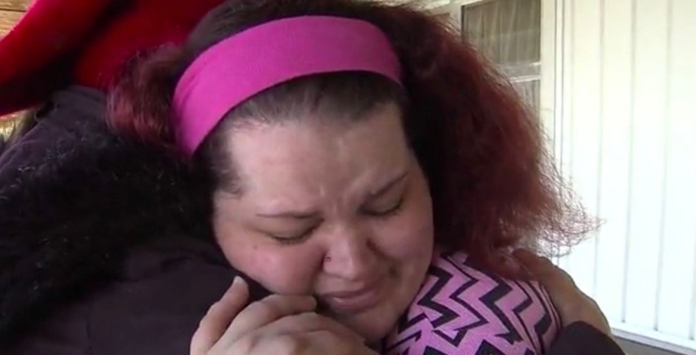 A recipient tearfully embracing a volunteer after receiving help